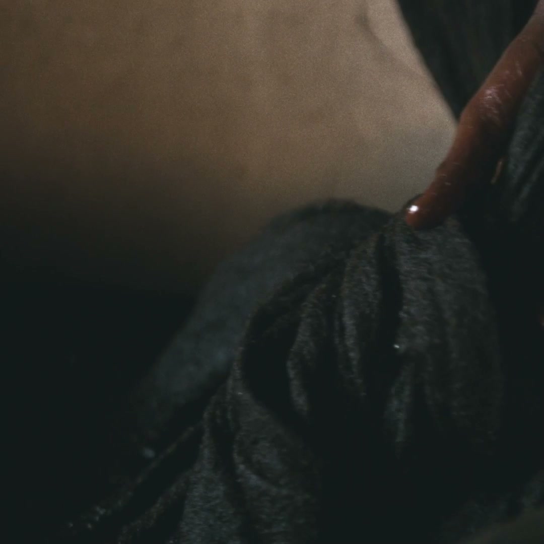 A pair of hands wringing a dark wet length of wool cloth