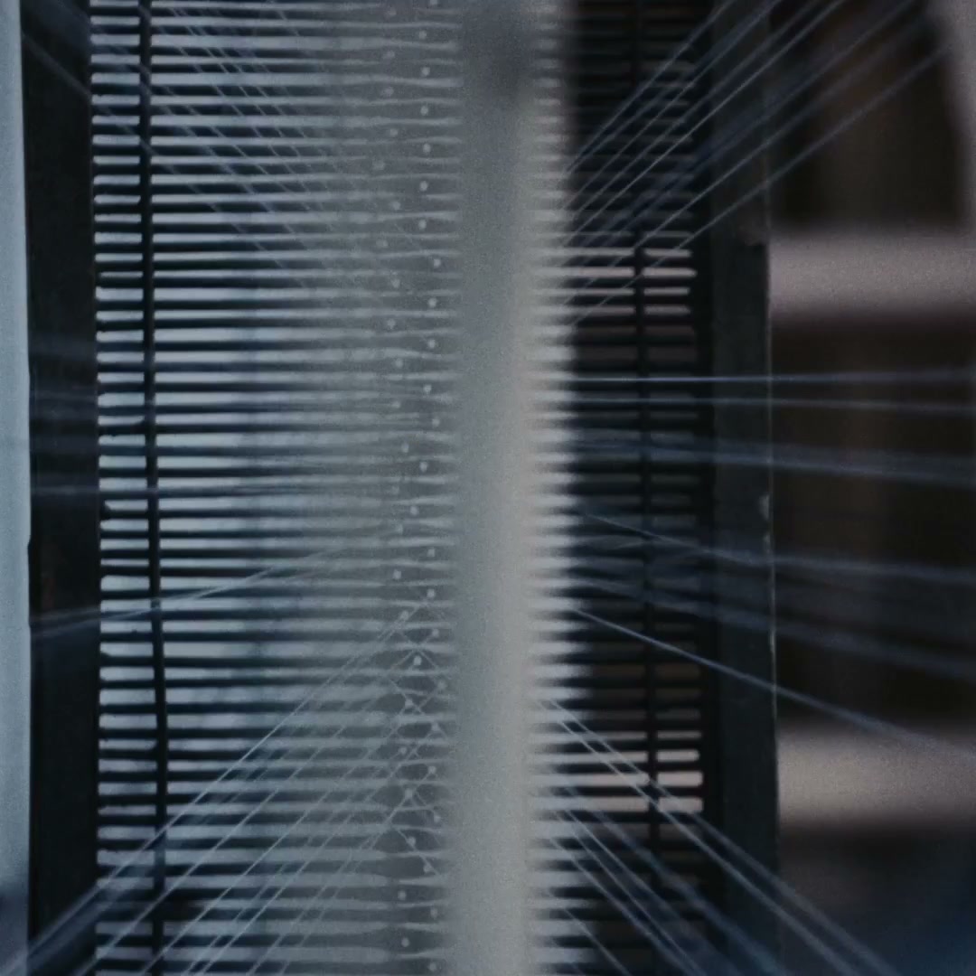 Close-up of fine warp threads running through the reed of a wooden handloom