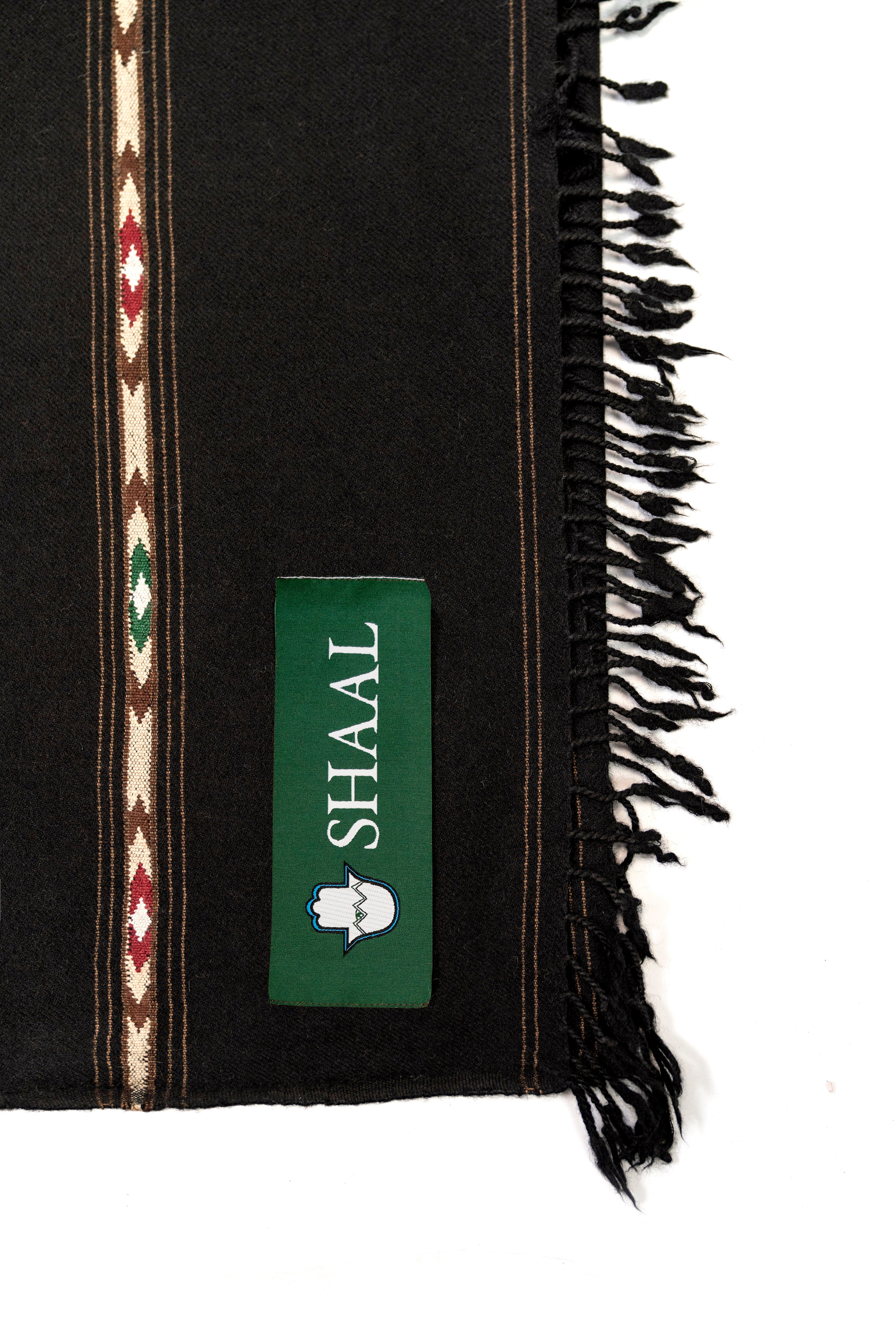 Black lambs wool wrap with decorative stripes and a green label on a white background