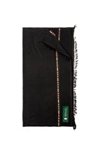 Black lambs wool wrap with fringes and a green label on a white background