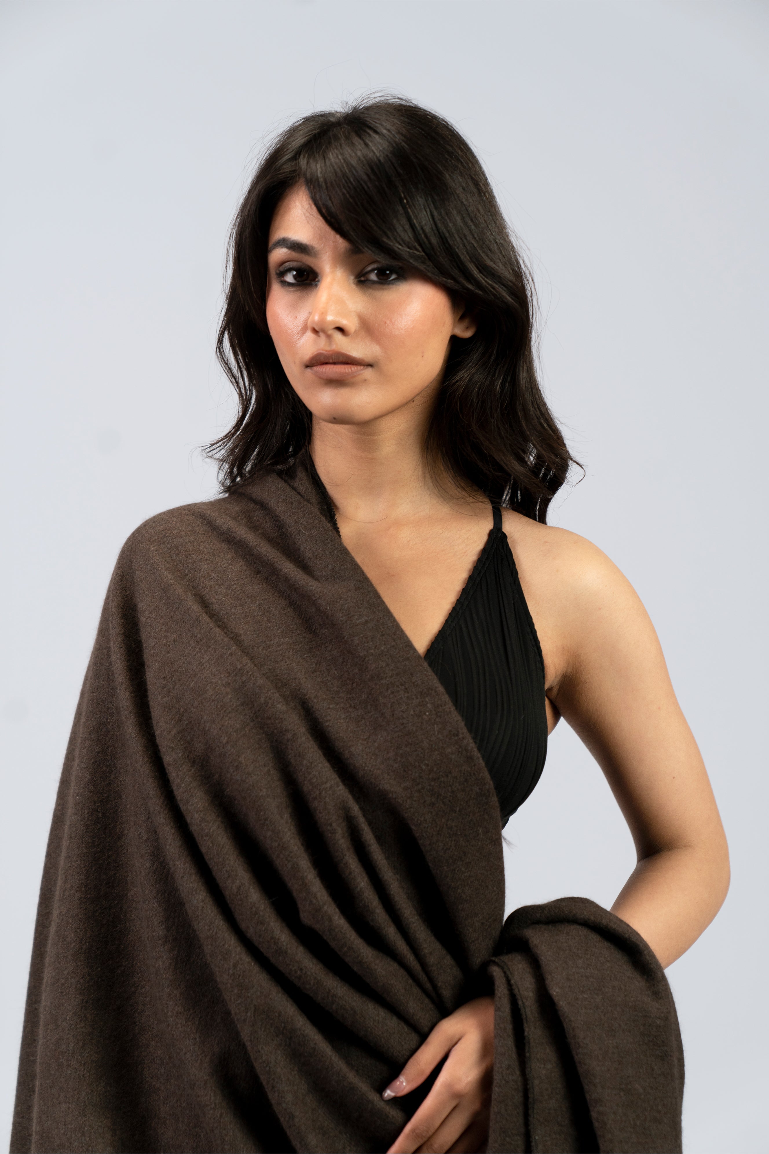 Brown handwoven wool shawl draped over model, close-up view