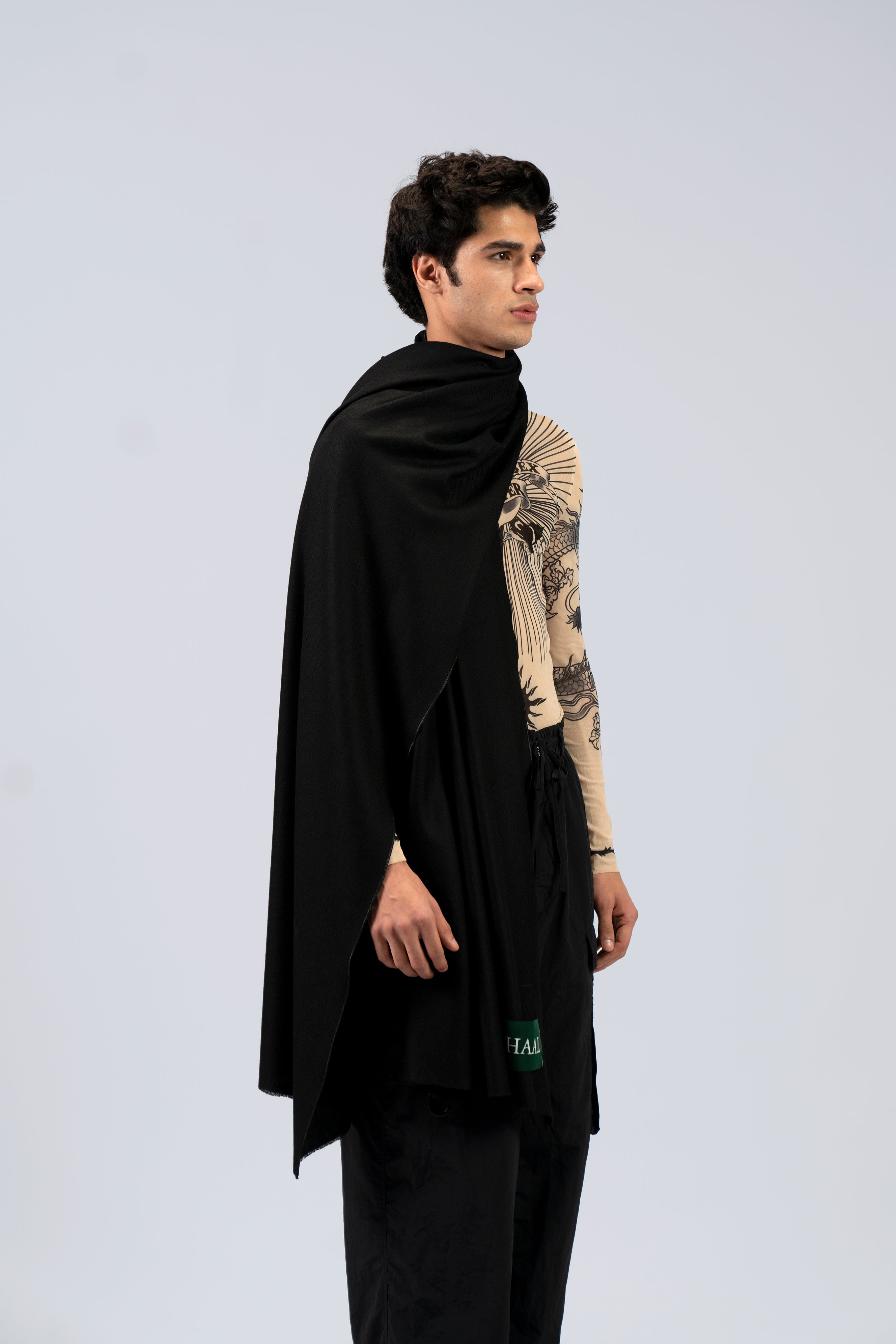 Black midweight wool shawl on male model in printed top, three-quarter side view