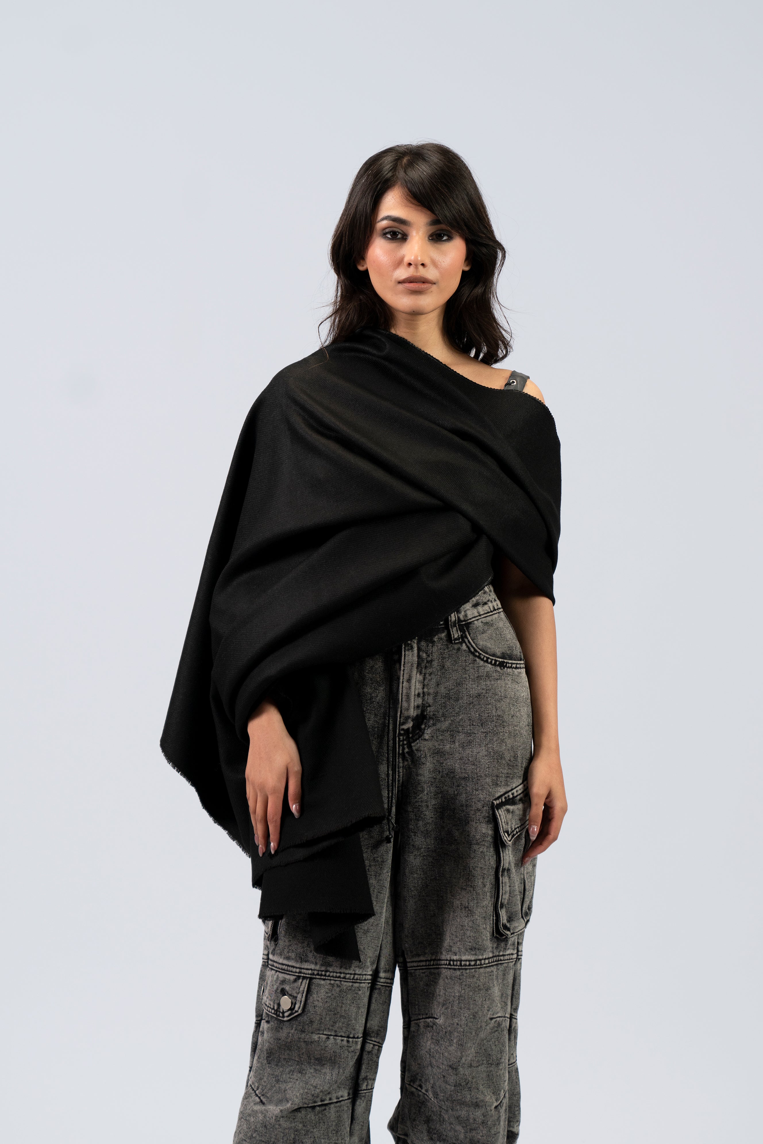 Black pashmina shawl draped across torso on female model, front view
