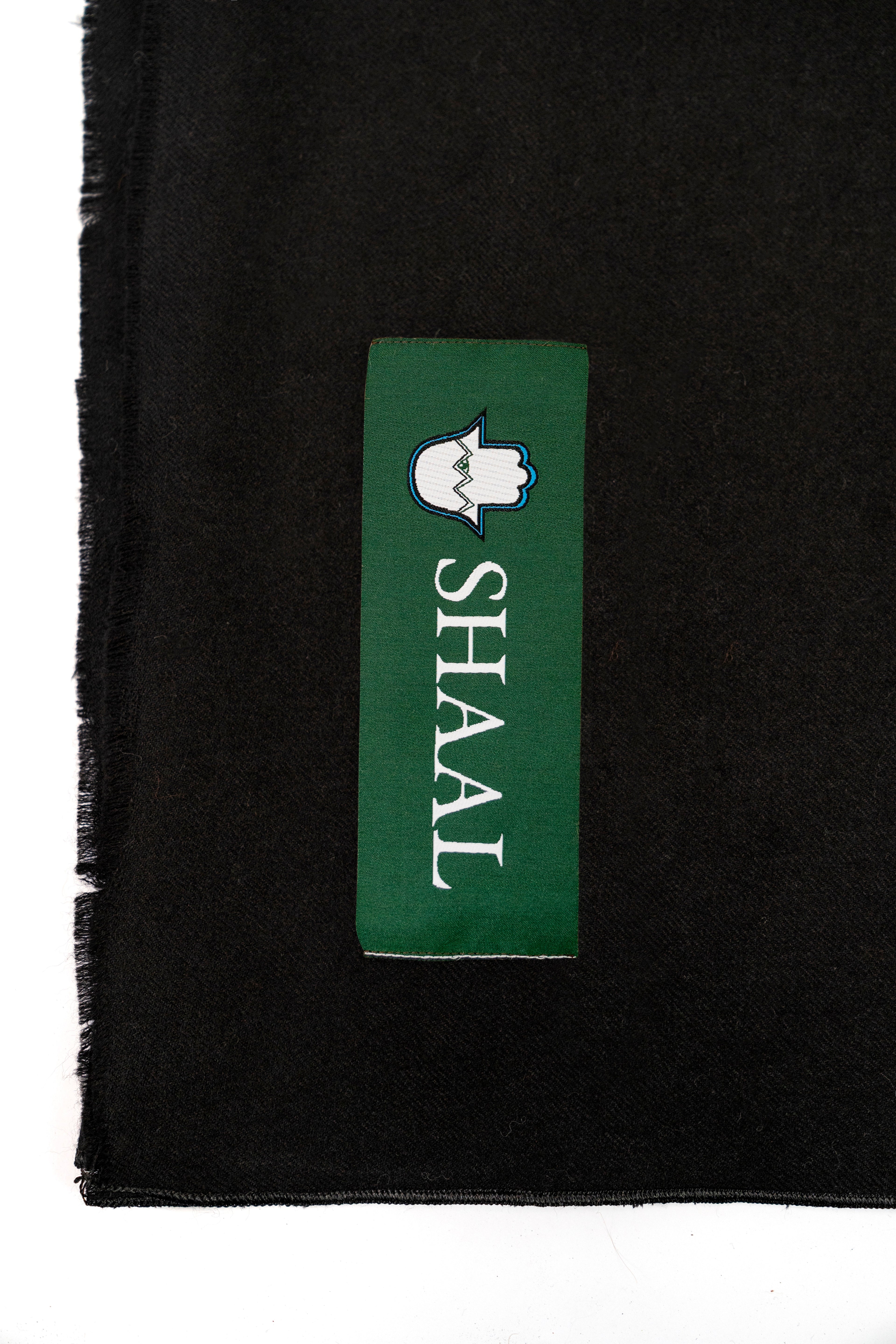 Black pashmina shawl detail of green SHAAL woven label