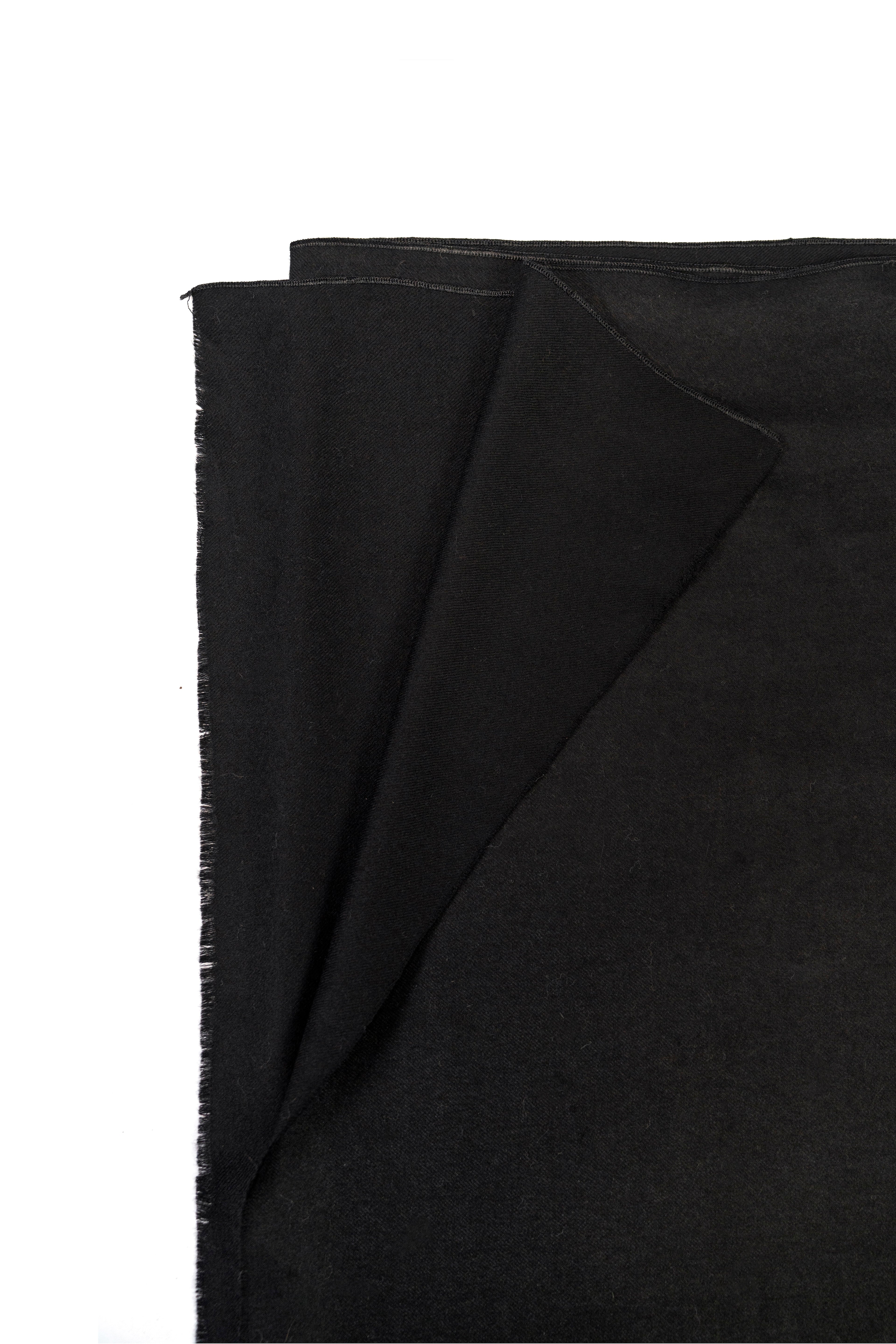 Black pashmina shawl folded corner on white background