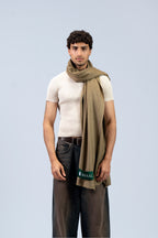 Gold pashmina shawl draped on male model in ribbed t-shirt, front view
