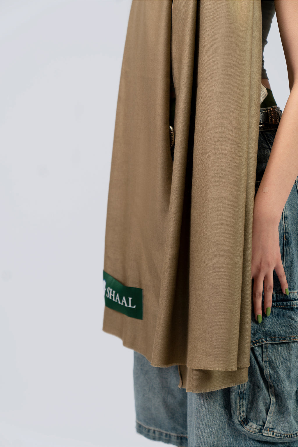 Gold pashmina shawl mid-body close-up with SHAAL label on female model