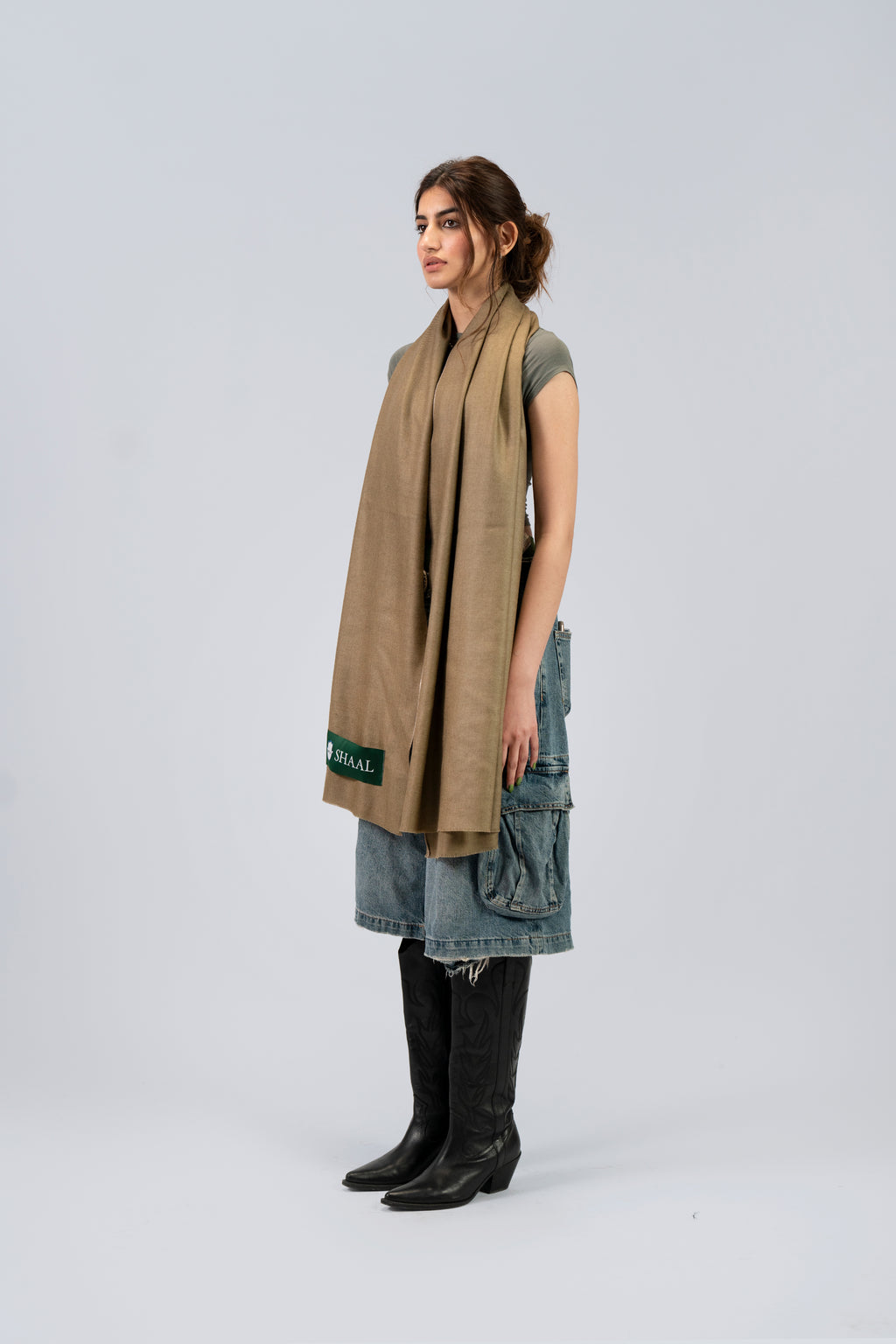 Gold pashmina shawl on female model with cowboy boots, three-quarter side view