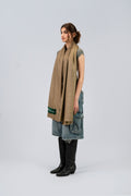 Gold pashmina shawl on female model with cowboy boots, three-quarter side view