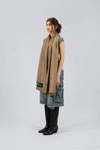 Gold pashmina shawl on female model with cowboy boots, three-quarter side view