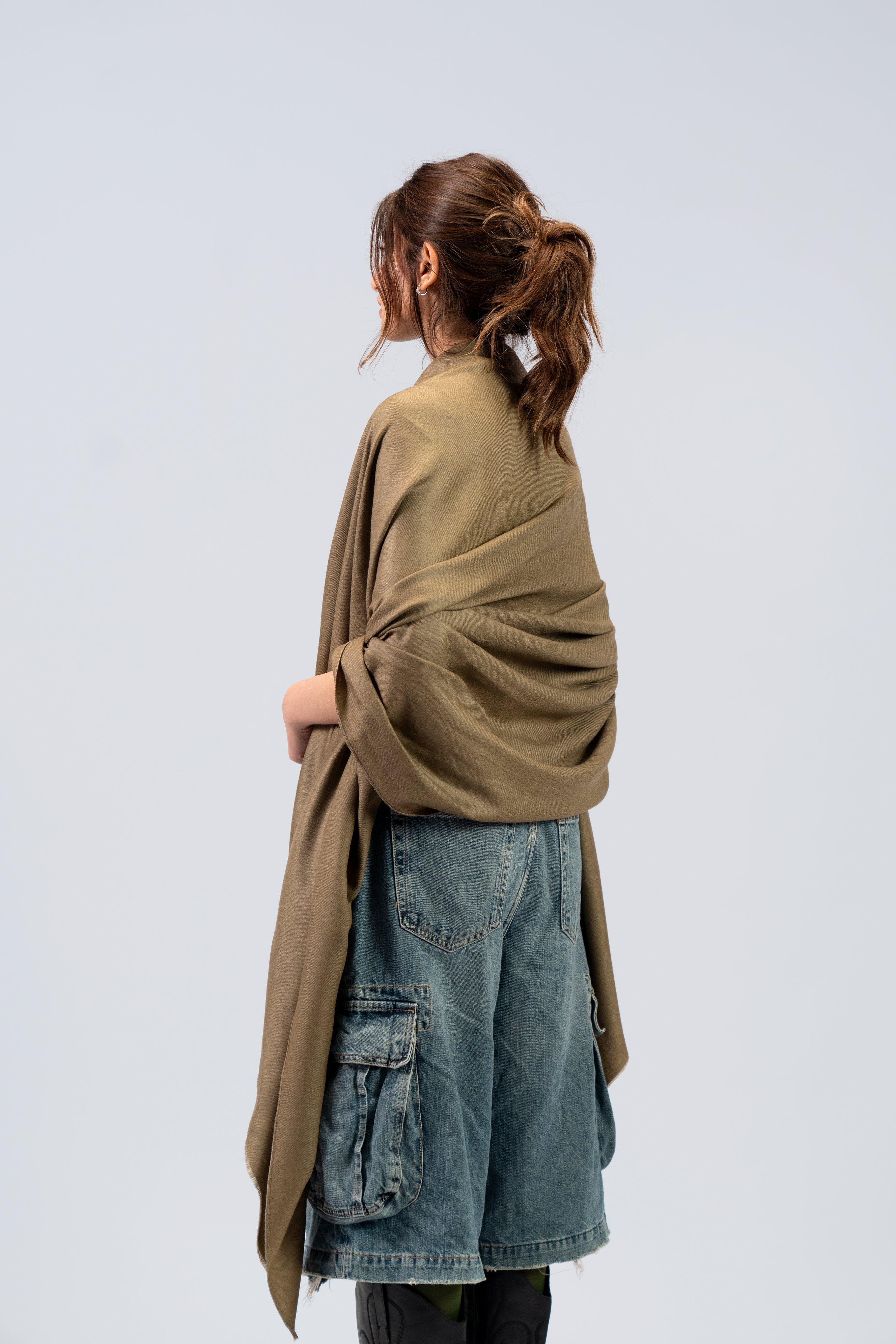 Gold pashmina shawl wrapped around female model from behind, back view